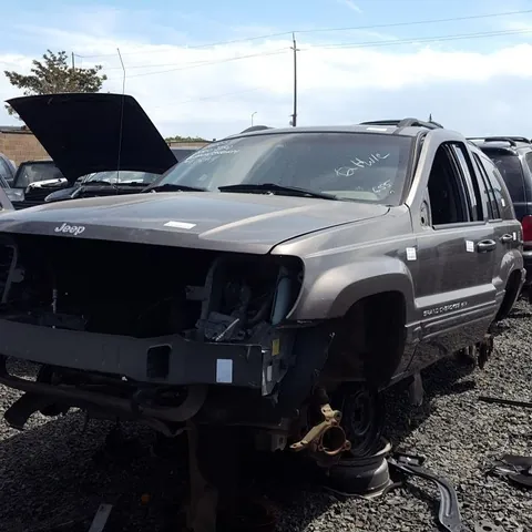 Grey Jeep Grand Cherokee with the bonnet raised and the wheels removed