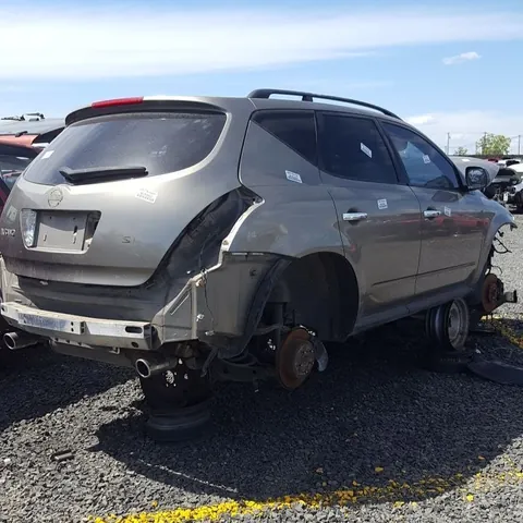 Silver crossover with rear-end damage, standing on its hubs