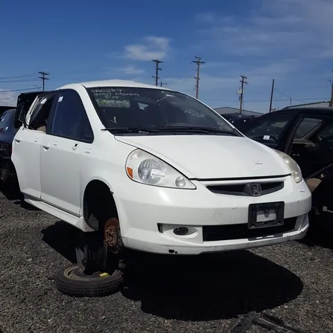 White compact hatchback raised on its hubs with the wheels off