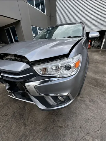 Silver sedan with the front bumper and headlight displaced by an impact
